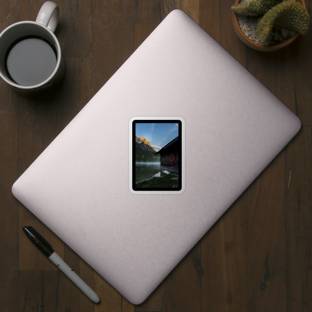 Boathouse with lifesaver Portrait. Amazing shot of a wooden house in the Ferchensee lake in Bavaria, Germany, in front of a mountain belonging to the Alps. Scenic foggy morning scenery at sunrise. by EviRadauscher